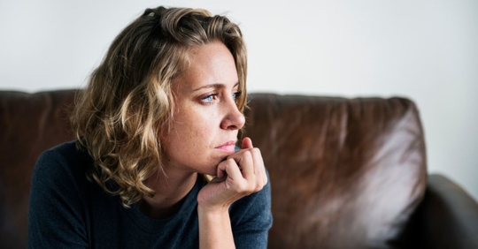 A depressed woman after learning her health care claim was denied. If this happens to you, contact the Law Offices of Scott Glovsky.