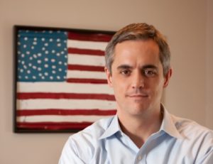 Tyrone Nelson standing in front of american flag
