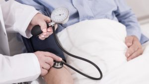 caregiver checking a patient's blood pressure