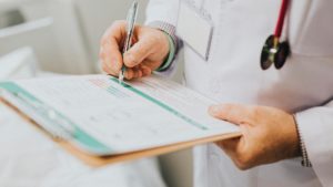 doctor writing on a clipboard